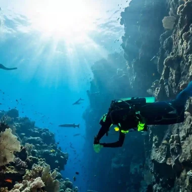 Zwei Taucher beim Specialty-Training in Amed, Bali: Ein Taucher mit Unterwasserscooter (DPV) und ein Buddy beim gemeinsamen Tauchgang im klaren Wasser.